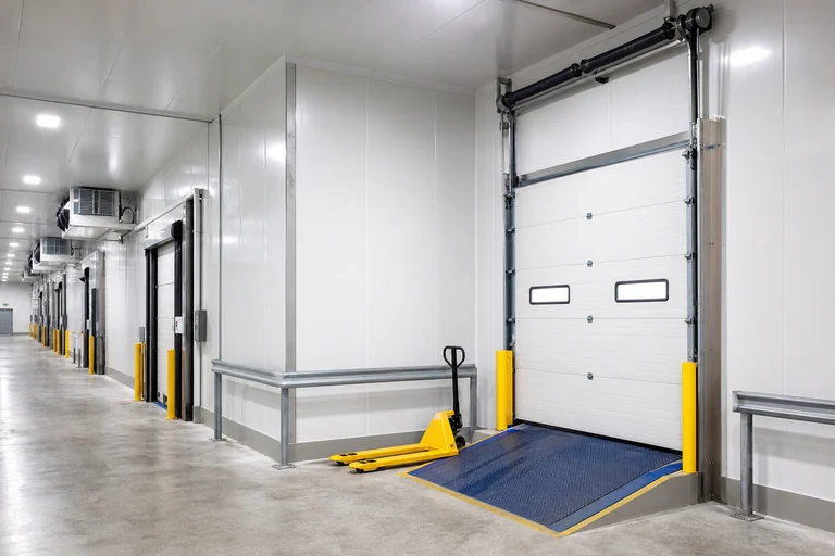 Cold store loading dock with insulated sectional doors and FRP gelcoat-lined walls