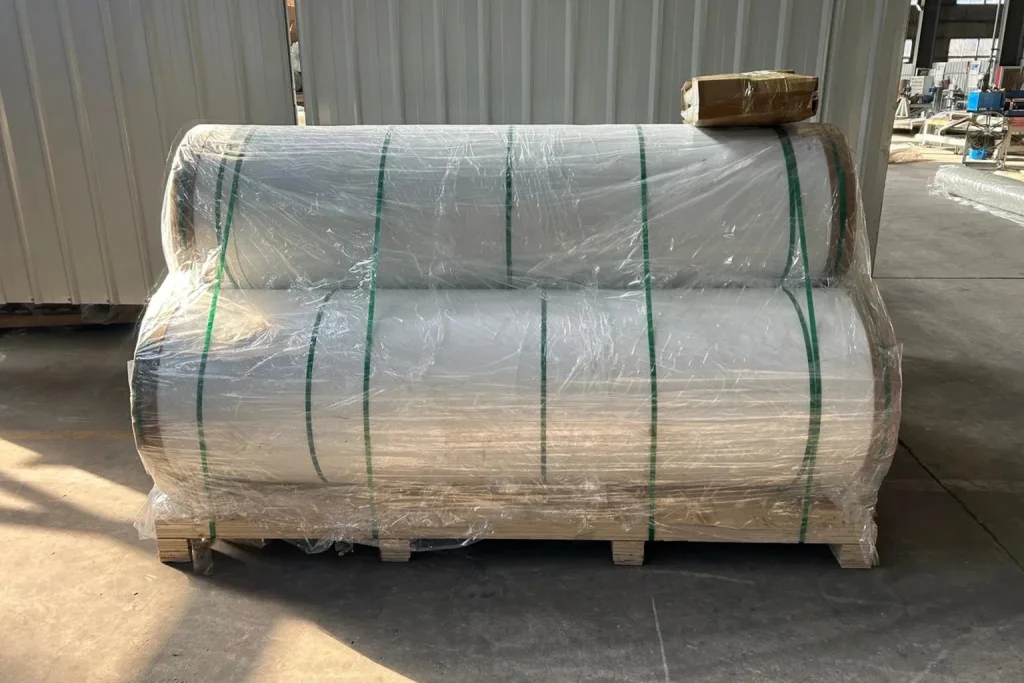 Three rolls of FRP gelcoat sheet wrapped in protective film and strapping on a wooden pallet